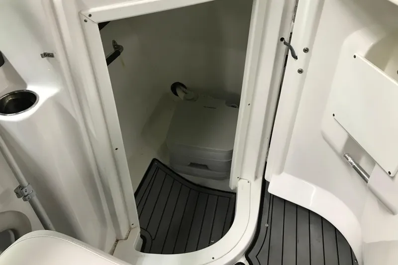 Slide: The Image of 2018 Rinker QX26 BR boat interior with compact marine toilet. - 11
