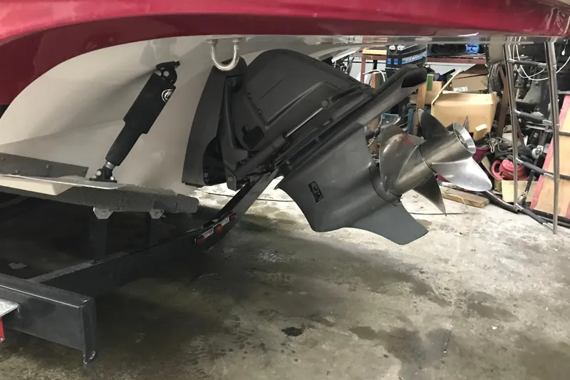 Slide: The Image of 2018 Rinker QX26 BR boat propeller and stern in a garage setting. - 20