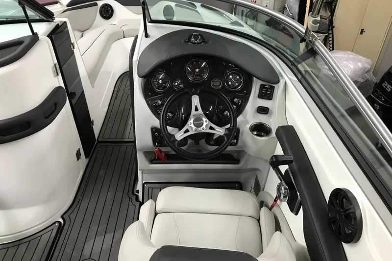 Slide: The Image of 2018 Rinker QX26 BR boat interior with steering wheel and dashboard controls. - 21