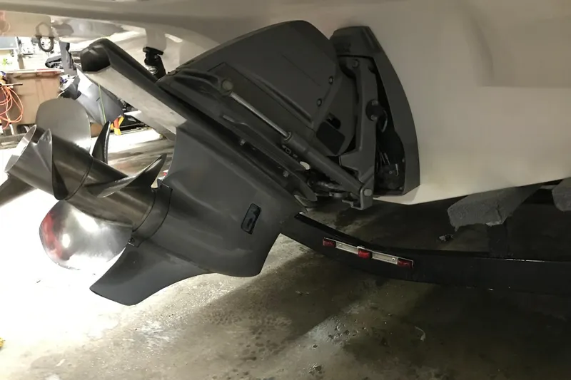 Slide: The Image of 2018 Rinker QX26 BR boat propeller and outdrive on trailer in garage. - 26