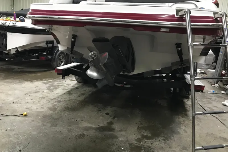 Slide: The Image of 2018 Rinker QX26 BR boat in garage, showing propeller and ladder. - 27