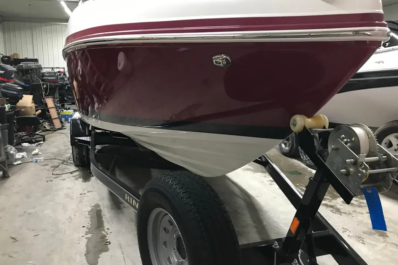 Slide: The Image of 2018 Rinker QX26 BR boat on trailer in a garage setting. - 31