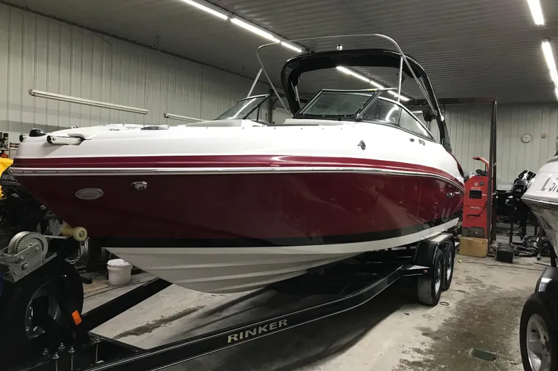 Slide: The Image of 2018 Rinker QX26 BR boat in a garage on a trailer. - 33