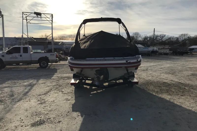 Slide: The Image of 2018 Rinker QX26 BR boat covered and parked on a trailer in a lot. - 4