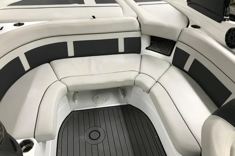 Slide: The Image of 2018 Rinker QX26 BR boat interior with white and gray seating, cup holders, and sleek design. - 7