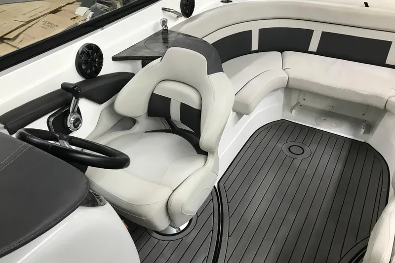 Slide: The Image of 2018 Rinker QX26 BR boat interior with sleek seating and modern steering wheel. - 8