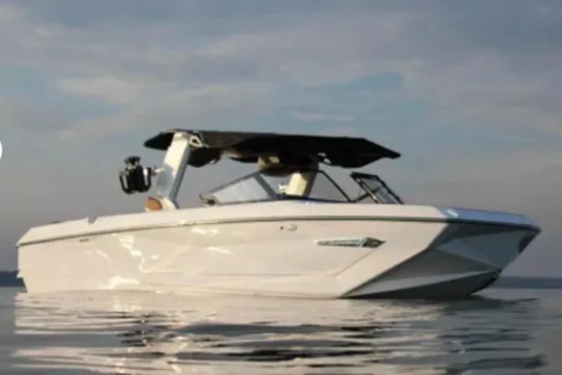 Slide: The Image of 2024 Nautique Super Air Nautique G25 boat on calm water at sunset. - 2