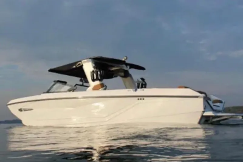 Slide: The Image of 2024 Nautique Super Air Nautique G25 boat on calm water at sunset. - 3