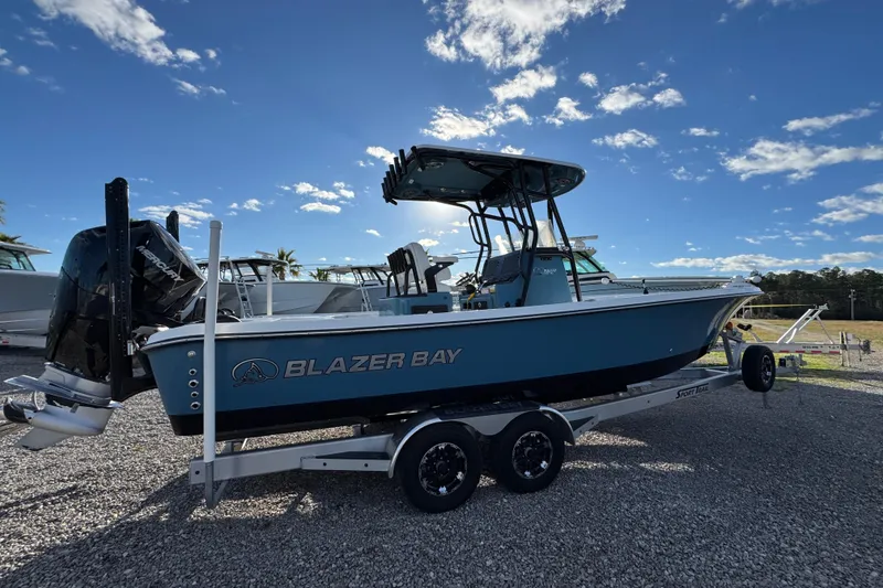 Slide: The Image of 2025 Blazer Bay 2700 Hybrid boat on trailer under clear blue sky. - 12
