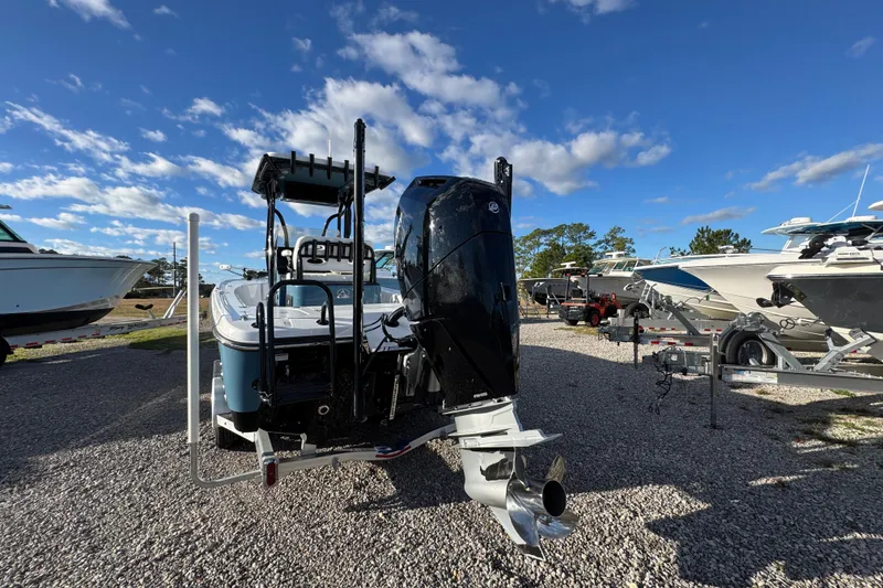 Slide: The Image of 2025 Blazer Bay 2700 Hybrid boat with powerful outboard motor, parked on gravel lot. - 16