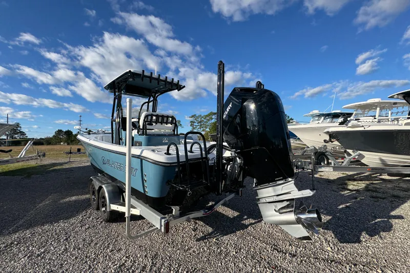 Slide: The Image of 2025 Blazer Bay 2700 Hybrid boat with Mercury engine on trailer under blue sky. - 17