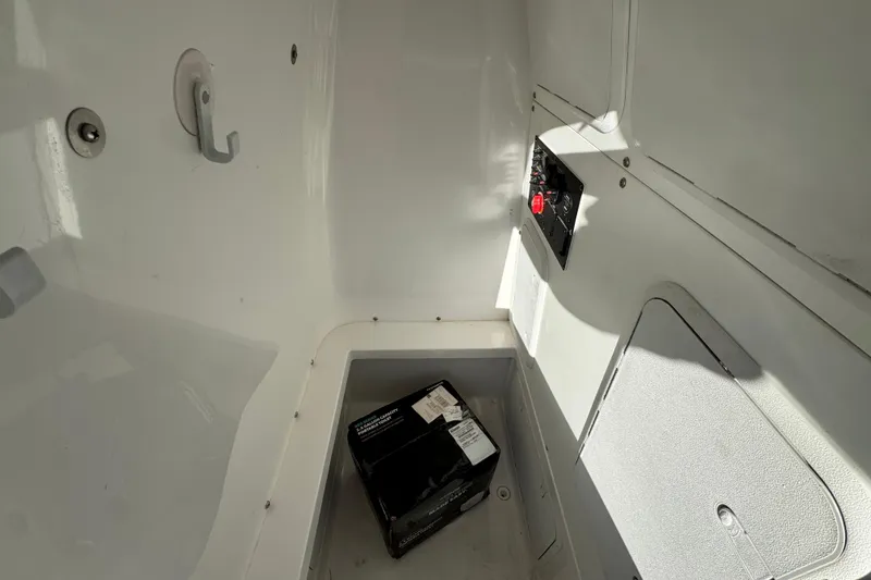 Slide: The Image of Interior of 2025 Blazer Bay 2700 Hybrid boat, featuring storage compartment and control panel. - 28