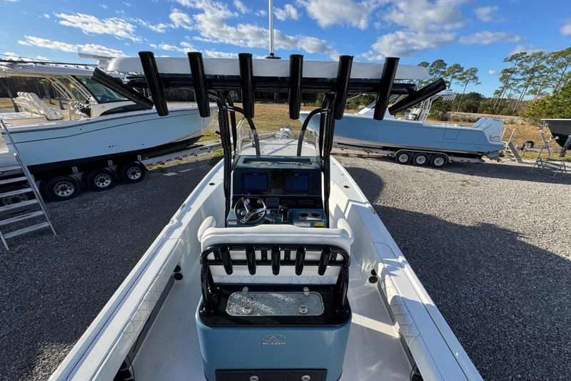 Slide: The Image of 2025 Blazer Bay 2700 Hybrid boat with advanced navigation system, parked on gravel lot. - 37