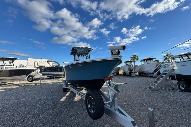 Slide: The Image of 2025 Blazer Bay 2700 Hybrid boat on trailer under blue sky. - 7