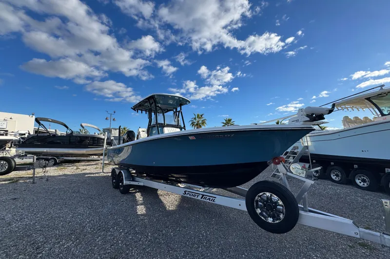 Slide: The Image of 2025 Blazer Bay 2700 Hybrid boat on trailer under blue sky. - 8