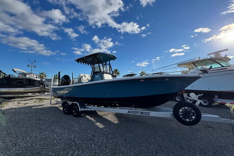 Slide: The Image of 2025 Blazer Bay 2700 Hybrid boat on trailer under blue sky. - 9