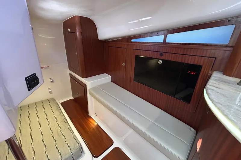 Slide: The Image of 2018 Pursuit OS 385 Offshore cabin interior with wood paneling and seating. - 16