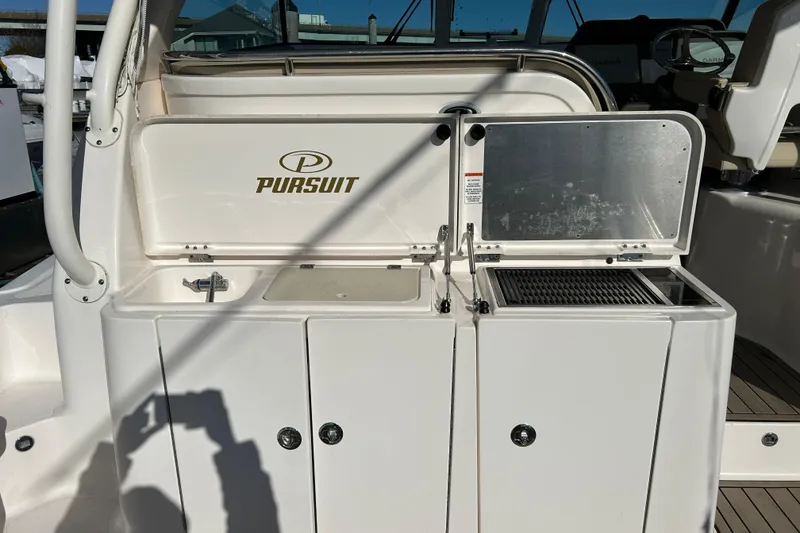Slide: The Image of 2018 Pursuit OS 385 Offshore boat interior with sink and grill station. - 6