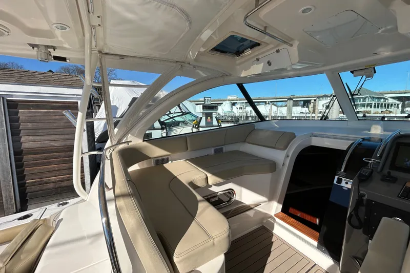 Slide: The Image of 2018 Pursuit OS 385 Offshore boat interior with beige seating and modern dashboard. - 7