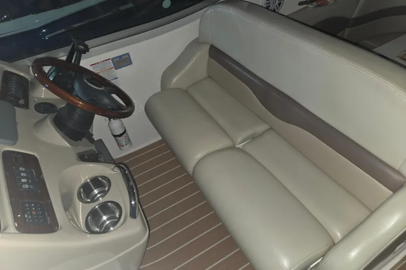 Slide: The Image of 2005 Chaparral Signature 310 boat interior with steering wheel and beige seating. - 11