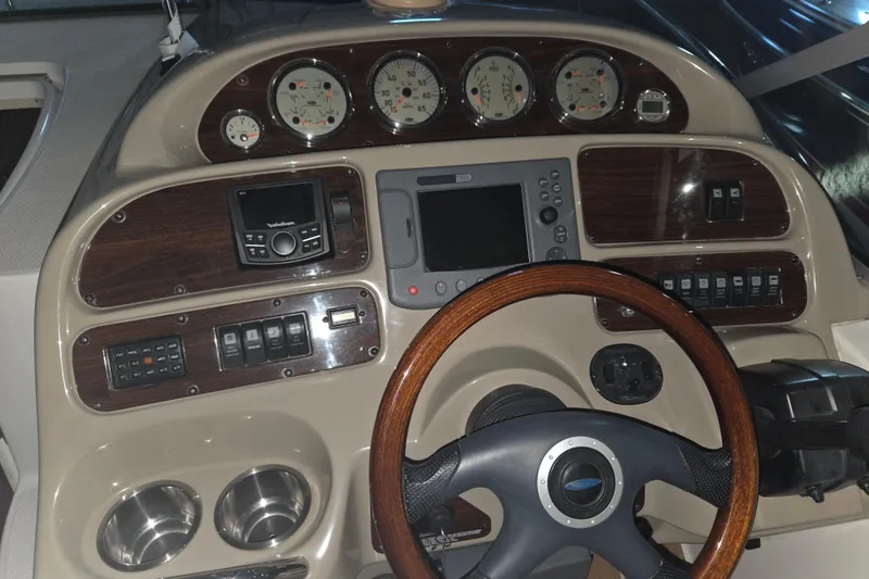 Slide: The Image of 2005 Chaparral Signature 310 dashboard with gauges, controls, and wood-trimmed steering wheel. - 12