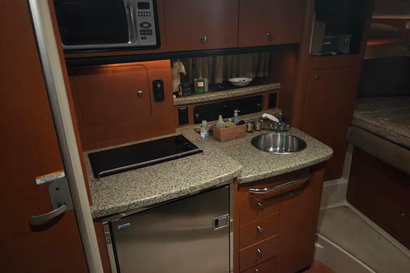 Slide: The Image of 2005 Chaparral Signature 310 yacht kitchen with granite countertops and stainless steel appliances. - 18