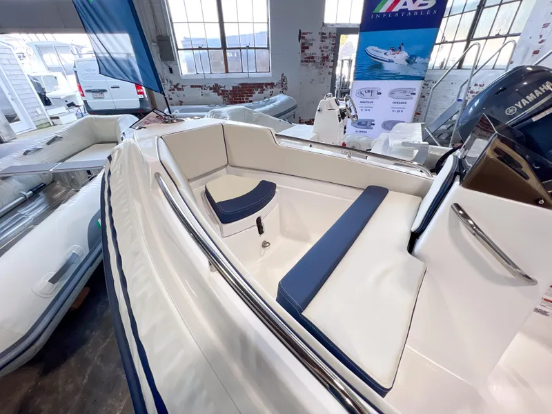 Slide: The Image of 2023 AB Inflatables Nautilus 13 DLX boat interior with seating and controls in showroom. - 11