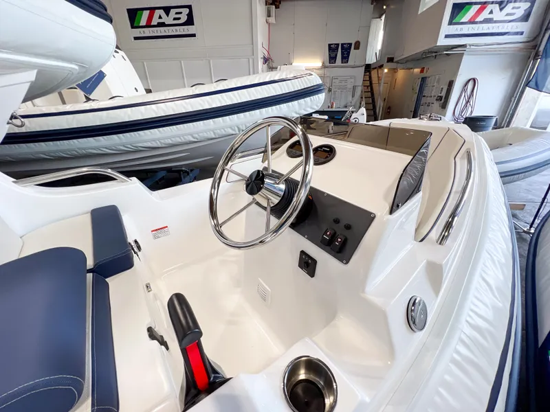 Slide: The Image of 2023 AB Inflatables Nautilus 13 DLX boat interior with steering wheel and controls. - 13