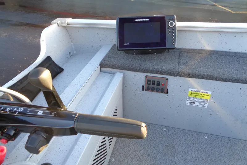 Slide: The Image of 2024 Lund 1400 Fury Tiller boat interior with control panel and fish finder. - 13