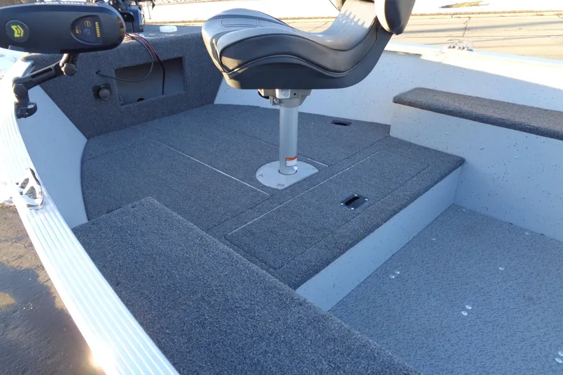 Slide: The Image of 2024 Lund 1400 Fury Tiller boat interior with swivel seat and carpeted deck. - 15