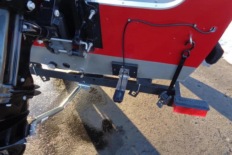 Slide: The Image of 2024 Lund 1400 Fury Tiller boat's rear view, showcasing motor and trailer components. - 18