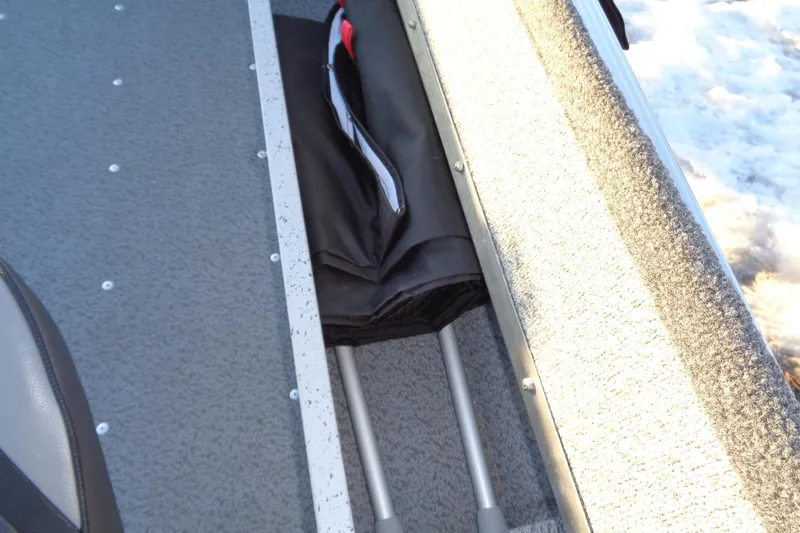 Slide: The Image of 2024 Lund 1400 Fury Tiller boat storage compartment with folded equipment inside. - 22