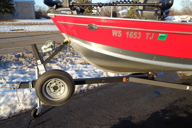 Slide: The Image of 2024 Lund 1400 Fury Tiller boat on trailer, snowy background, red hull. - 8
