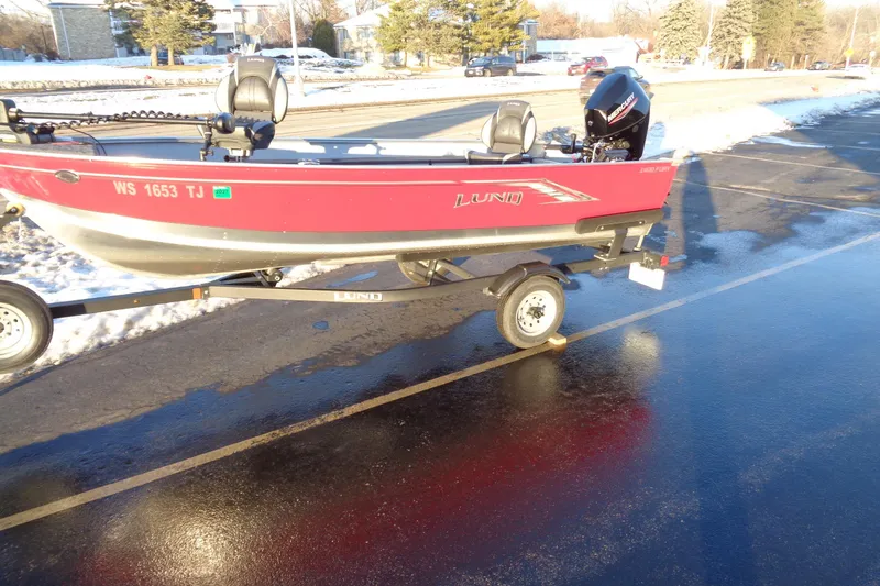 Slide: The Image of 2024 Lund 1400 Fury Tiller boat on trailer in snowy parking lot. - 9