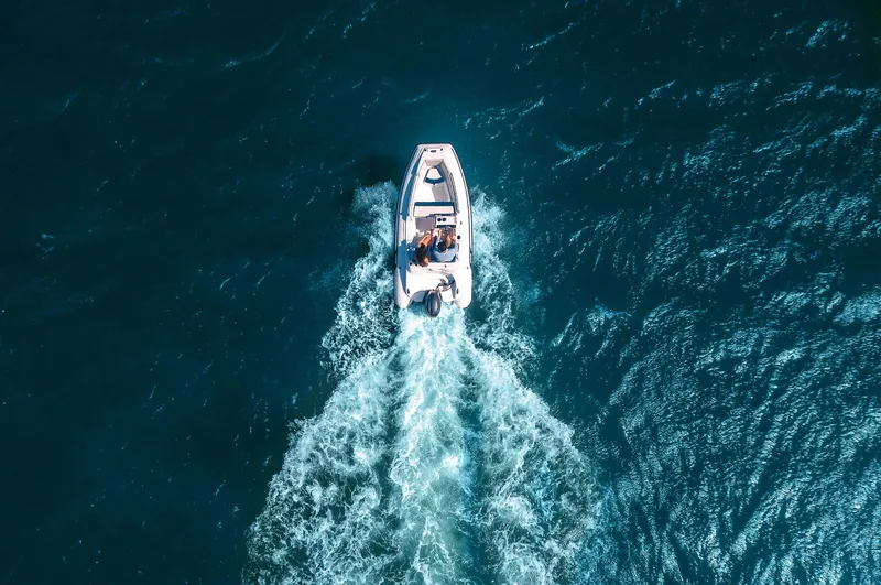 Slide: The Image of 2024 AB Inflatables Nautilus 13 DLX cruising on open water, aerial view. - 5