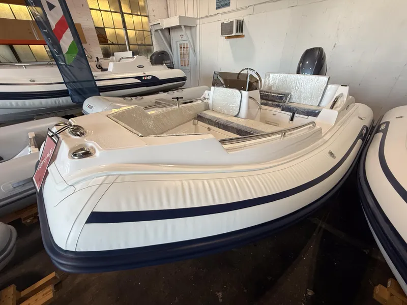 Slide: The Image of 2024 AB Inflatables Nautilus 13 DLX boat displayed indoors, featuring sleek design and modern seating. - 2