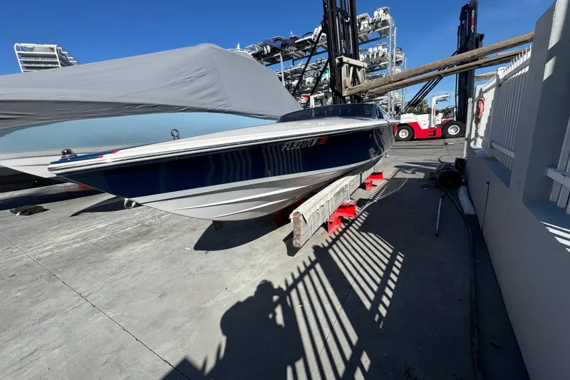 Slide: The Image of 2002 Donzi 22 Shelby GT boat on dry dock under clear blue sky. - 2