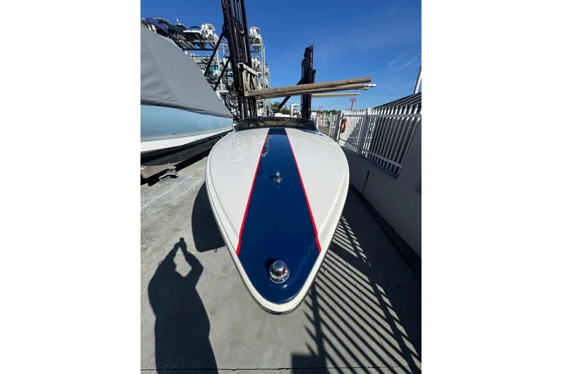 Slide: The Image of 2002 Donzi 22 Shelby GT boat with blue and red stripe, docked under clear sky. - 4