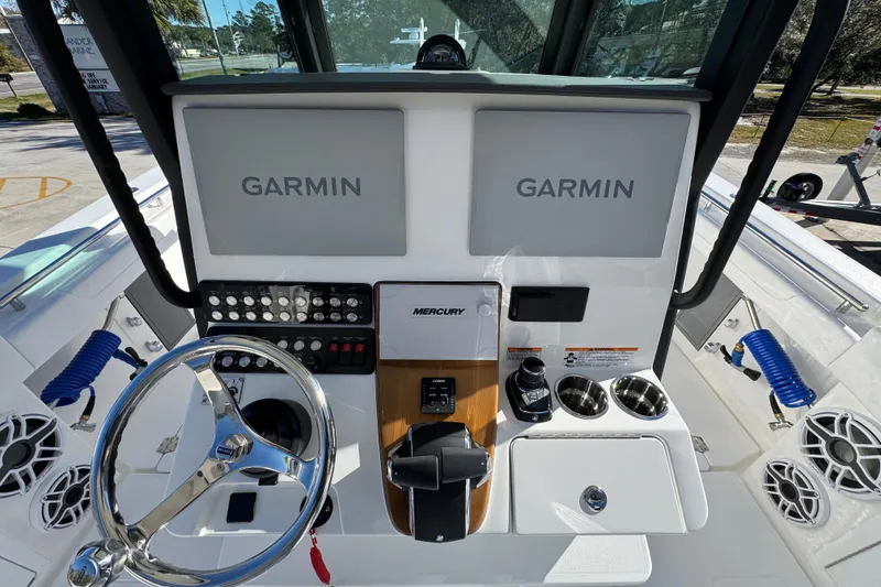 Slide: The Image of 2026 Caymas 34 CT boat dashboard with Garmin displays and Mercury controls. - 28