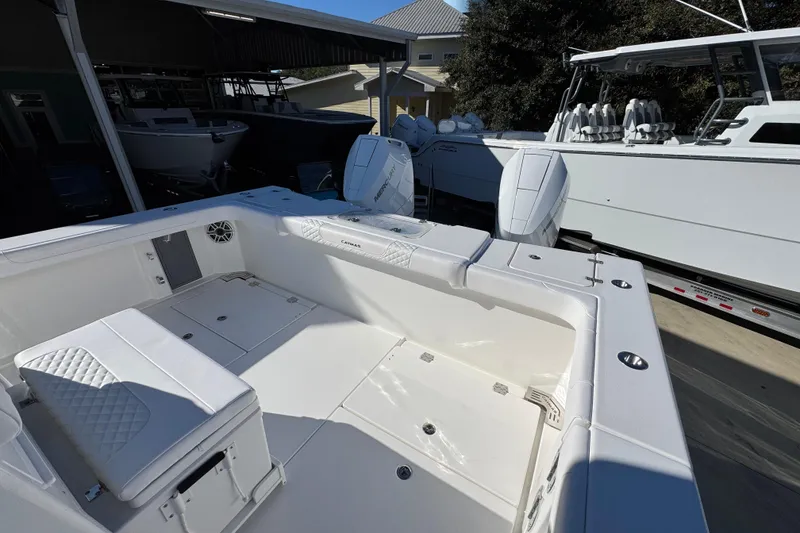 Slide: The Image of 2026 Caymas 34 CT boat interior with white seating and dual Mercury engines. - 36