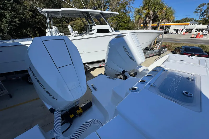 Slide: The Image of 2026 Caymas 34 CT boat with dual Mercury outboard engines, parked outdoors. - 40