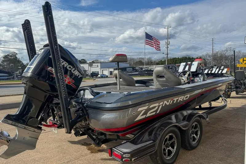 Slide: The Image of 2016 Nitro Z21 Pro boat with Mercury engine, parked outdoors, American flag in background. - 5