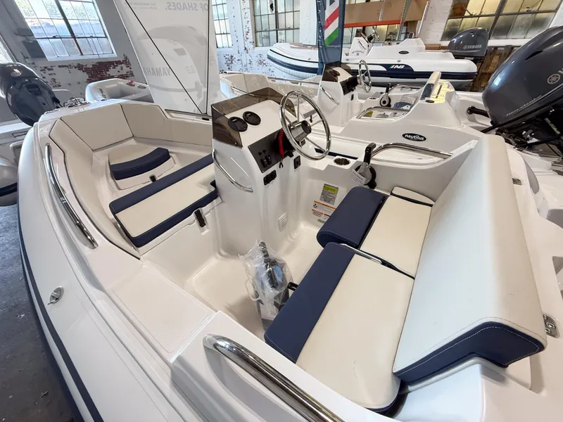 Slide: The Image of 2024 AB Inflatables Nautilus 13 DLX boat interior with seating and steering console. - 2