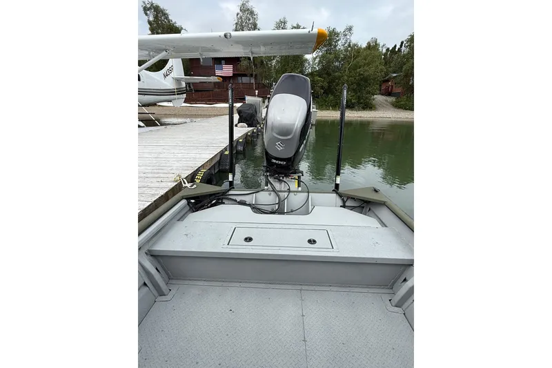 Slide: The Image of 2026 SeaArk 2672 CUB boat with outboard motor docked by a lake. - 5