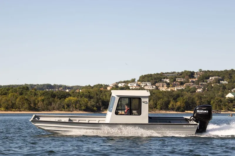 Slide: The Image of 2026 SeaArk 2672 CUB boat cruising on a lake with scenic background. - 7