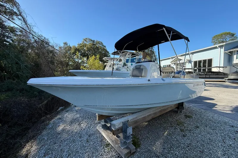 The Image of 2026 Key West 189 FS boat with canopy, displayed outdoors on gravel. - 0