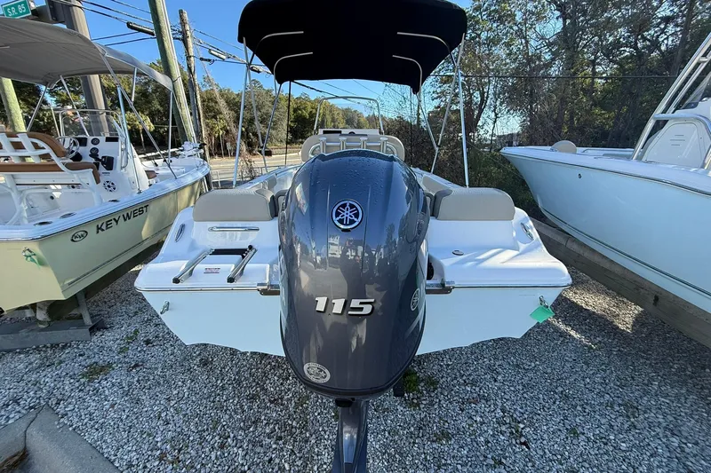Slide: The Image of 2026 Key West 189 FS boat with Yamaha 115 outboard motor, parked on gravel. - 2