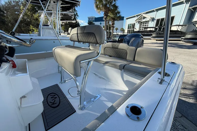 Slide: The Image of 2026 Key West 189 FS boat interior with seating and steering console, docked outdoors. - 9