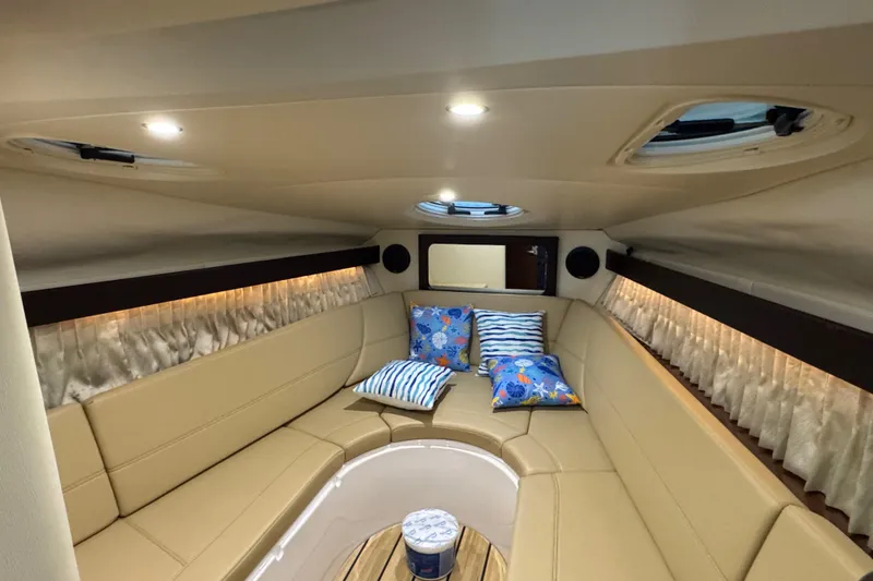 Slide: The Image of Interior of 2014 Regal 28 Express boat with beige seating and decorative pillows. - 12