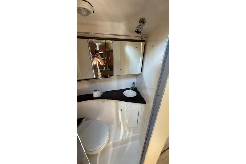 Slide: The Image of 2014 Regal 28 Express boat bathroom with sink, mirror, and toilet. - 19